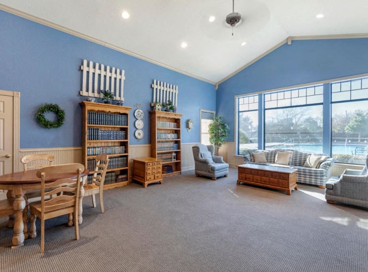 Resident lounge area with blue walls, vaulted ceilings, wooden furniture, and a couch with an accent chair